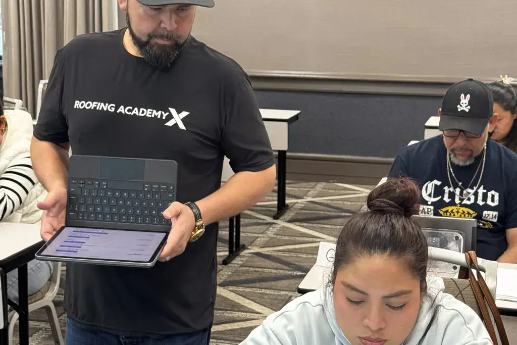 Roofing Academy X instructor helping a student on an iPad in class