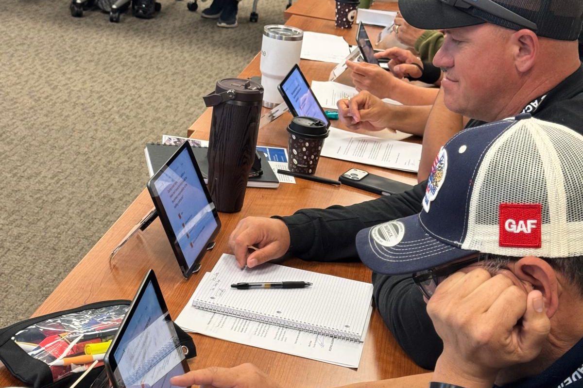 Roofing Academy X students studying on iPads during the Illinois roofing license class
