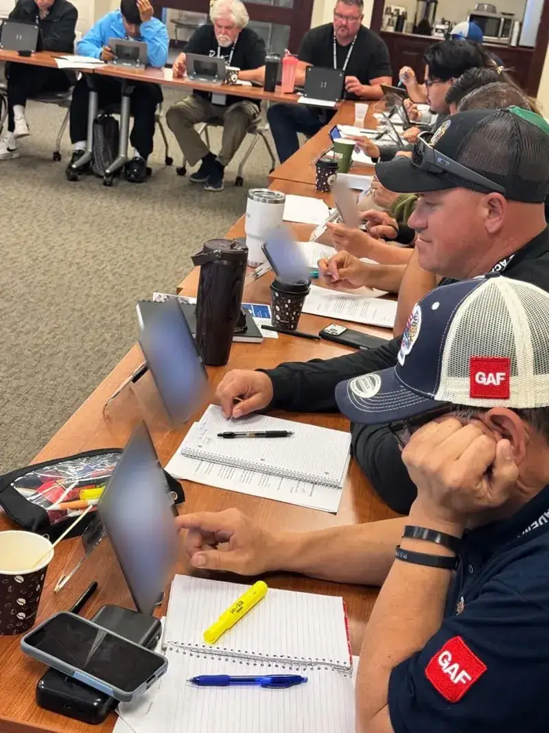 Roofing contractors working through the Roofing Academy X iPad system in class